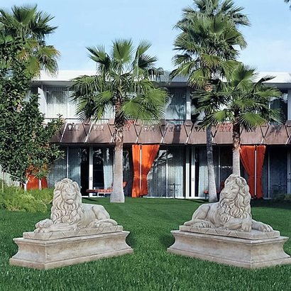 Statue en pierre couple de lions couchés sur socles