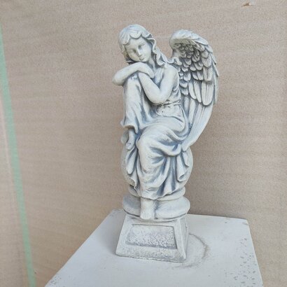 statue ange pensif assis sur une boule