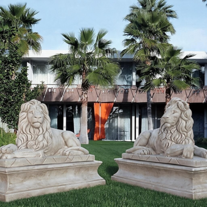 Statue en pierre couple de lions couchés sur socles