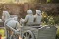 Statue couple petits vieux sur charrette cheval